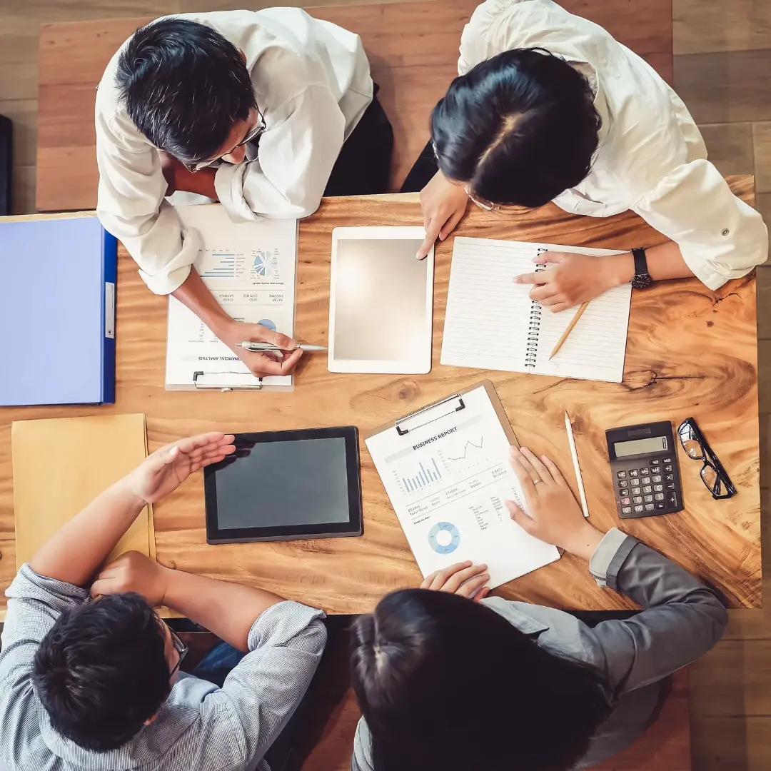 Group of 4 people looking over tablet